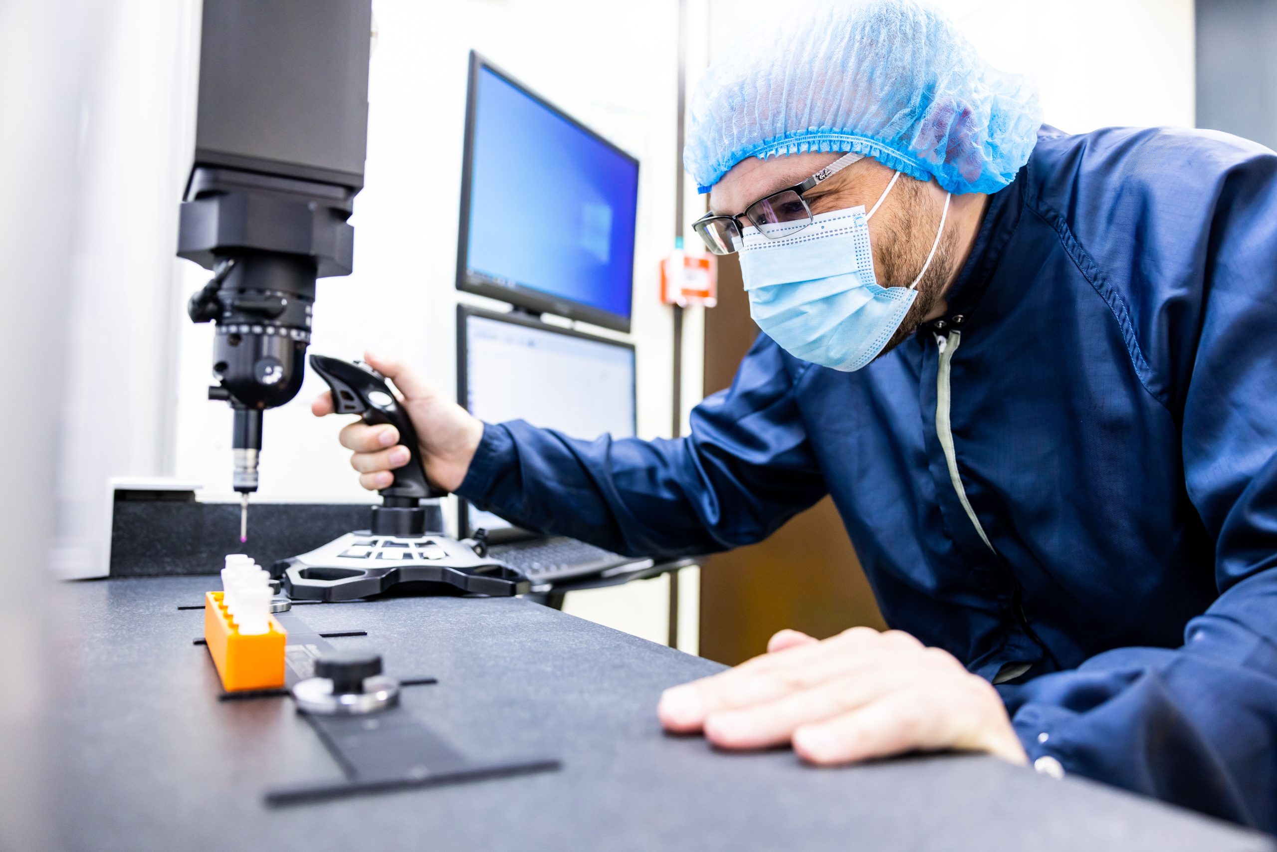 Image of a Meridian Medical Lab technician wearing PPE leaning over a counter top