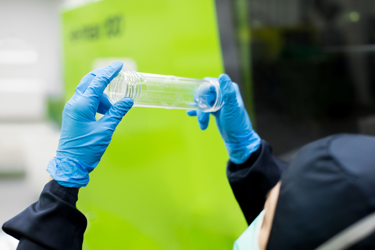 Technician inspecting a clear plastic orthopaedic device component, manufactured under ISO 13485 conditions at Meridian Medical.