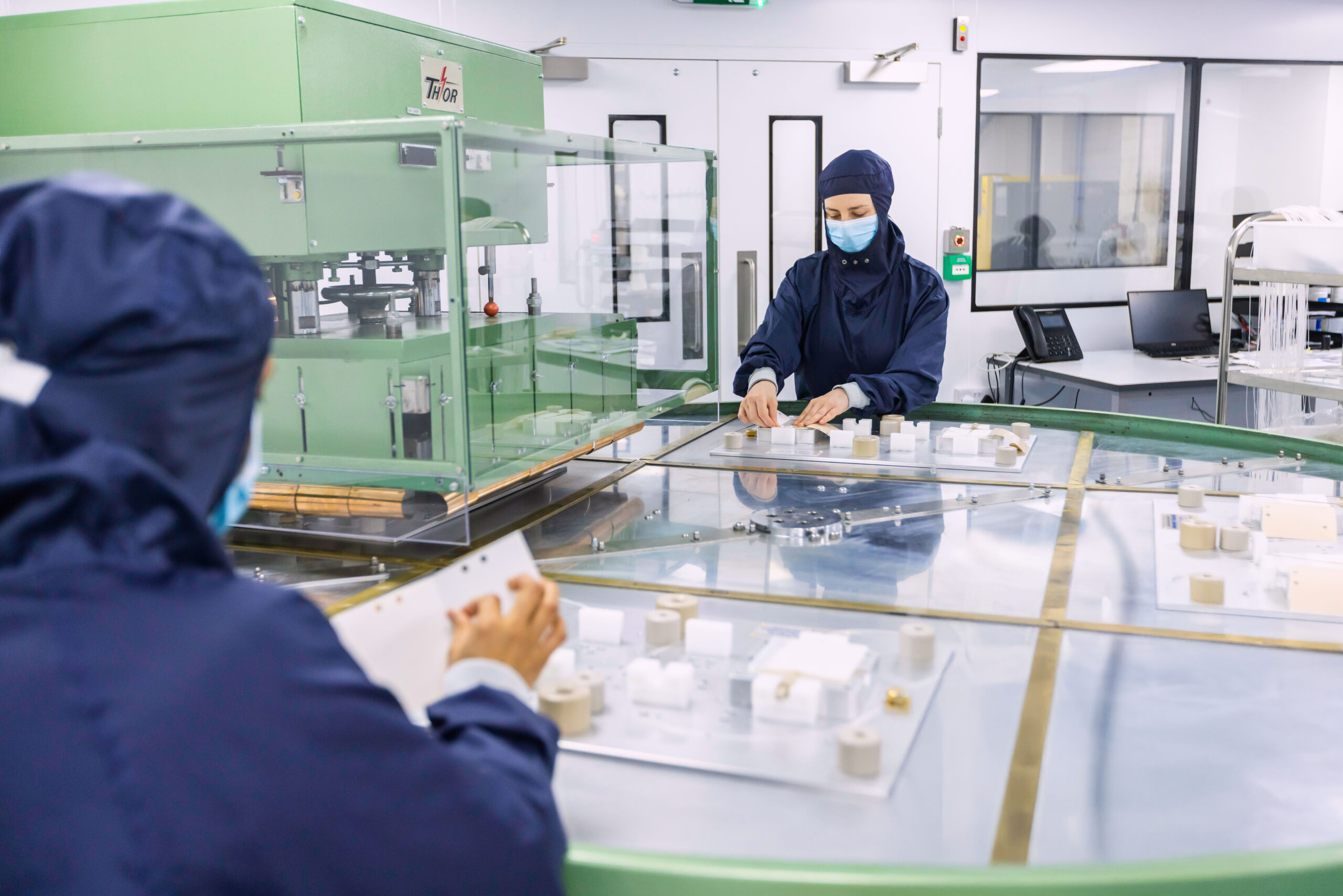 Cleanroom technicians assembling film-based wound care and surgical device components with precision tools at Meridian Medical