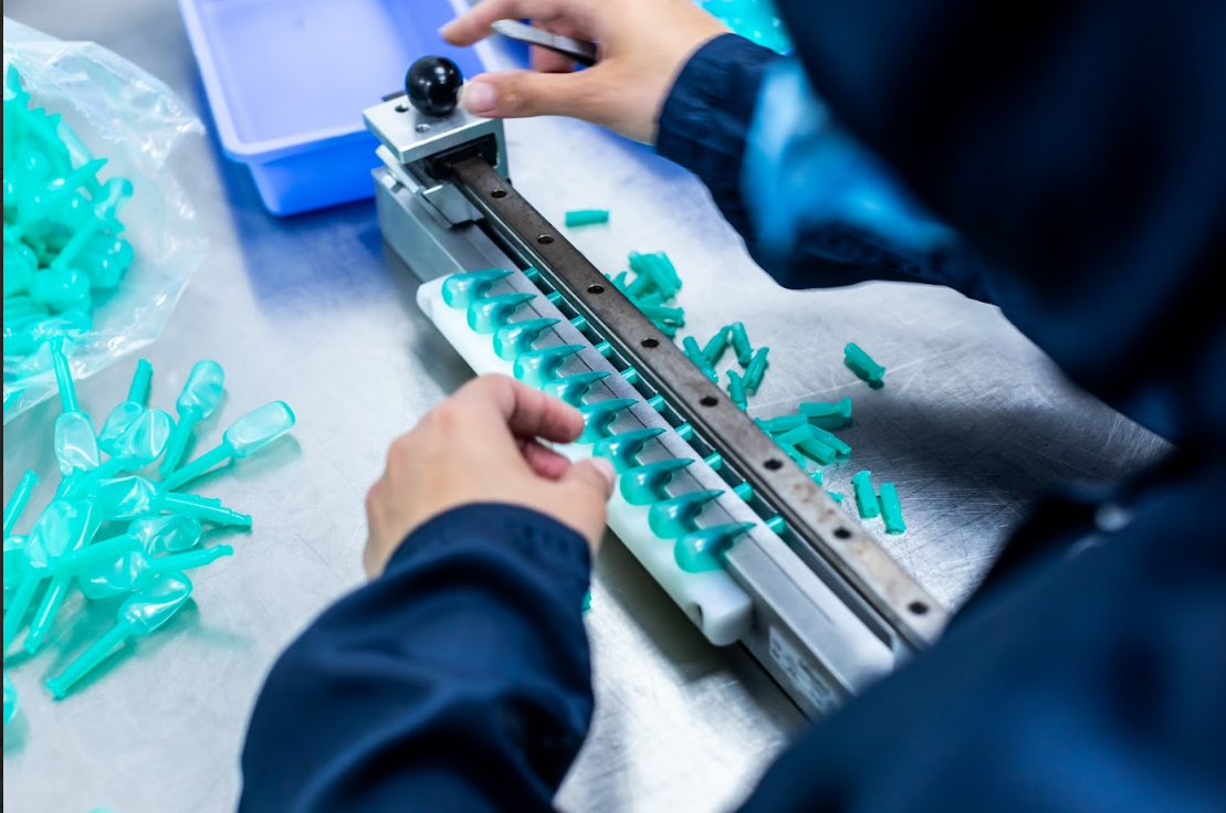 Close-up of a cleanroom technician trimming PVC Balloons used in urology devices such as catheters at Meridian Medical.